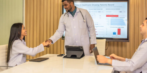 Team of doctors discuss healthcare big data to analyze patient satisfaction trends, waiting status, turnover rates aiming to identify areas for improvement, create cost effective management plans.